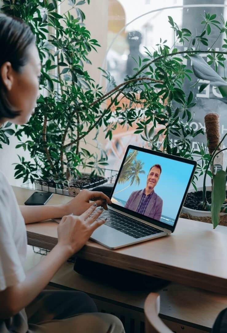 About Emile Du Toit Online: A woman speaking to Emile on a laptop.